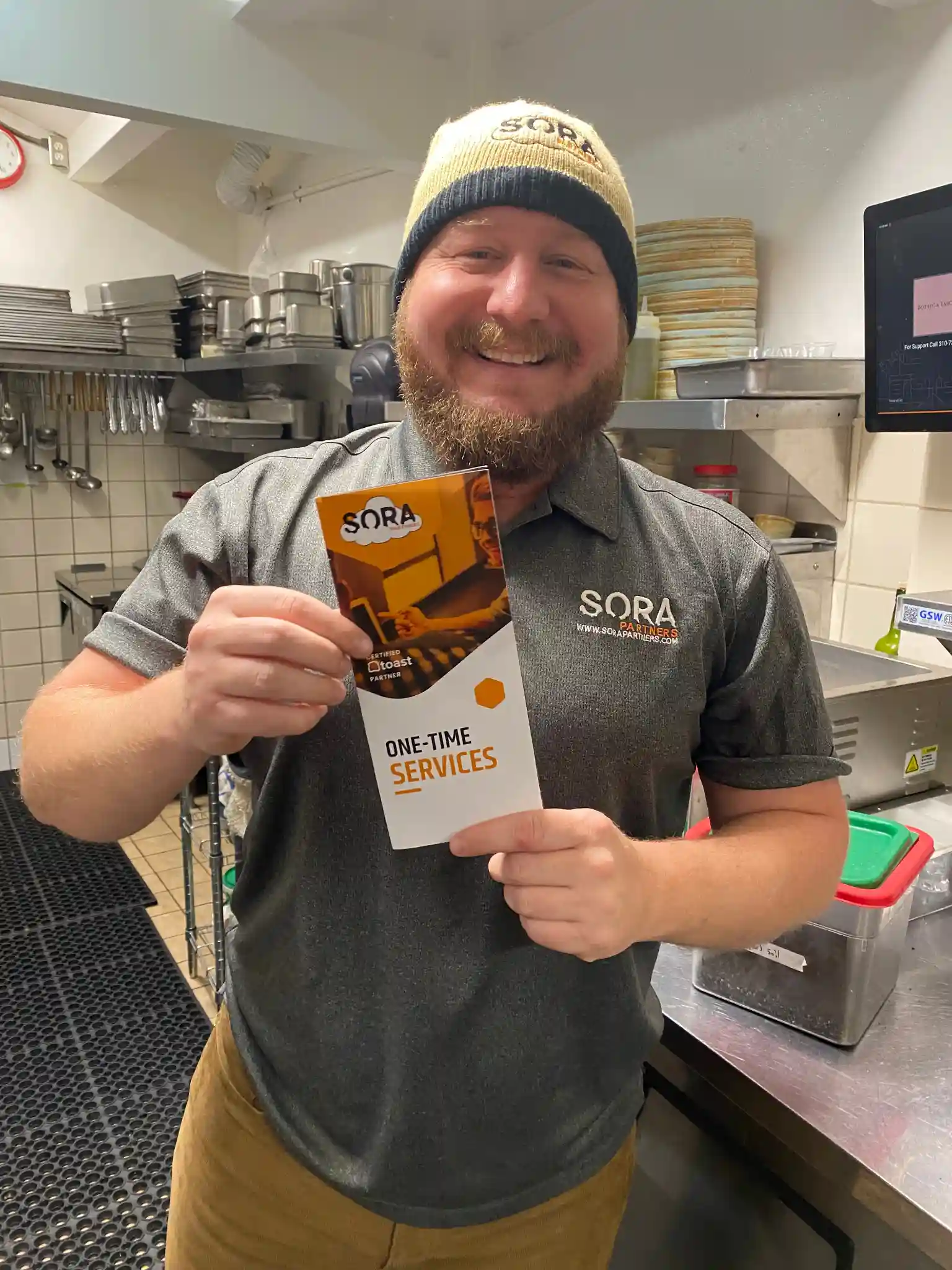 Streamlined POS setup: Sora Partners technician presents our brochure featuring one-time POS system services.